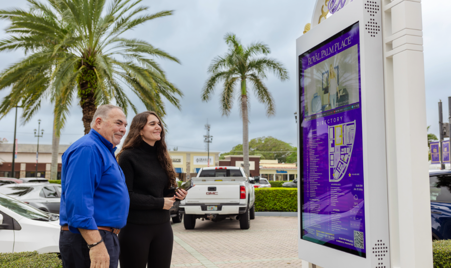 older man and younger woman looking at signage together